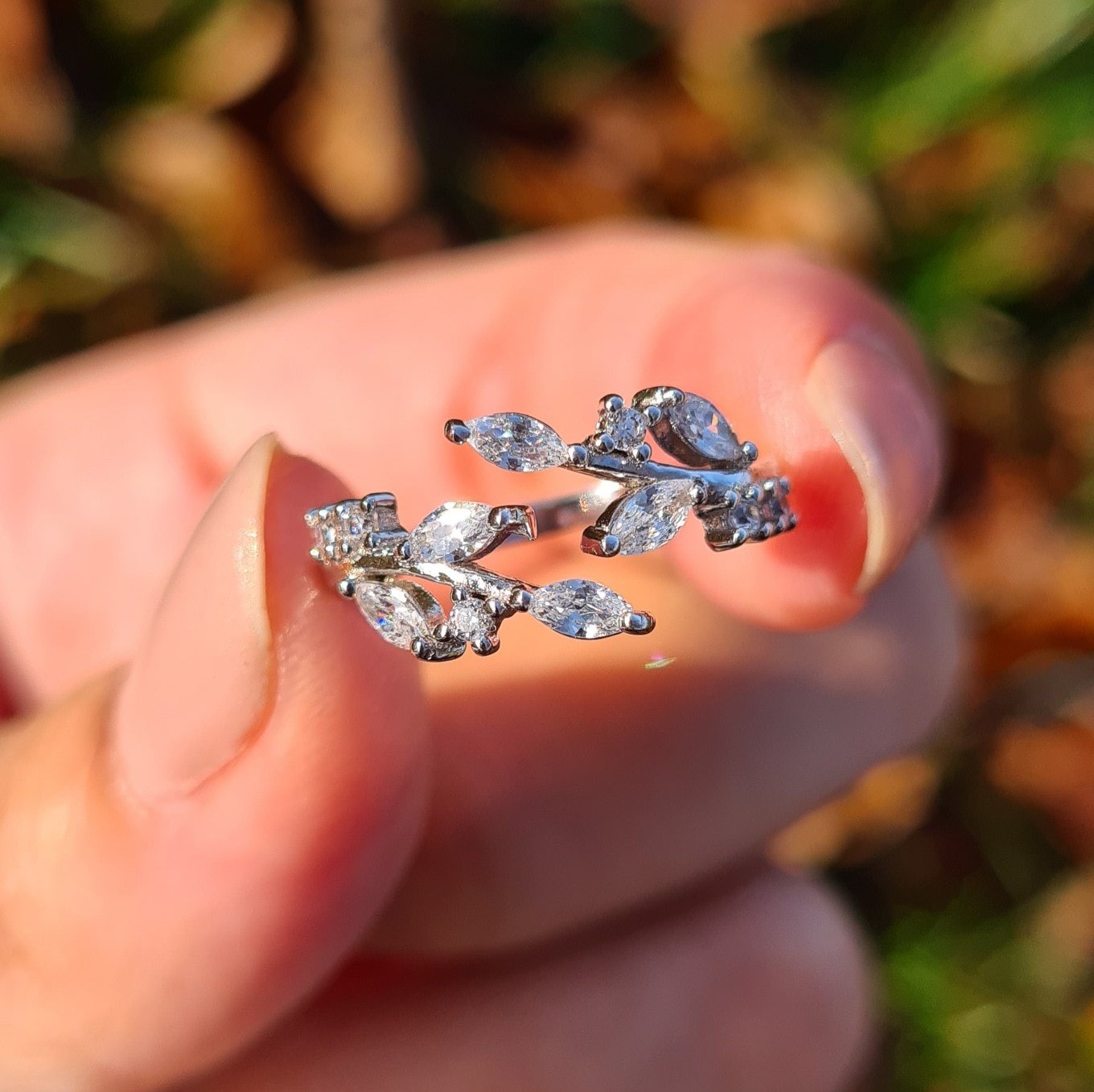 Adjustable sterling silver leaf ring with simulated diamonds on hand
