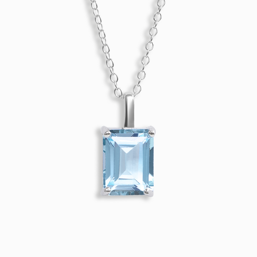 Blue topaz emerald cut pendant necklace in sterling silver on white background
