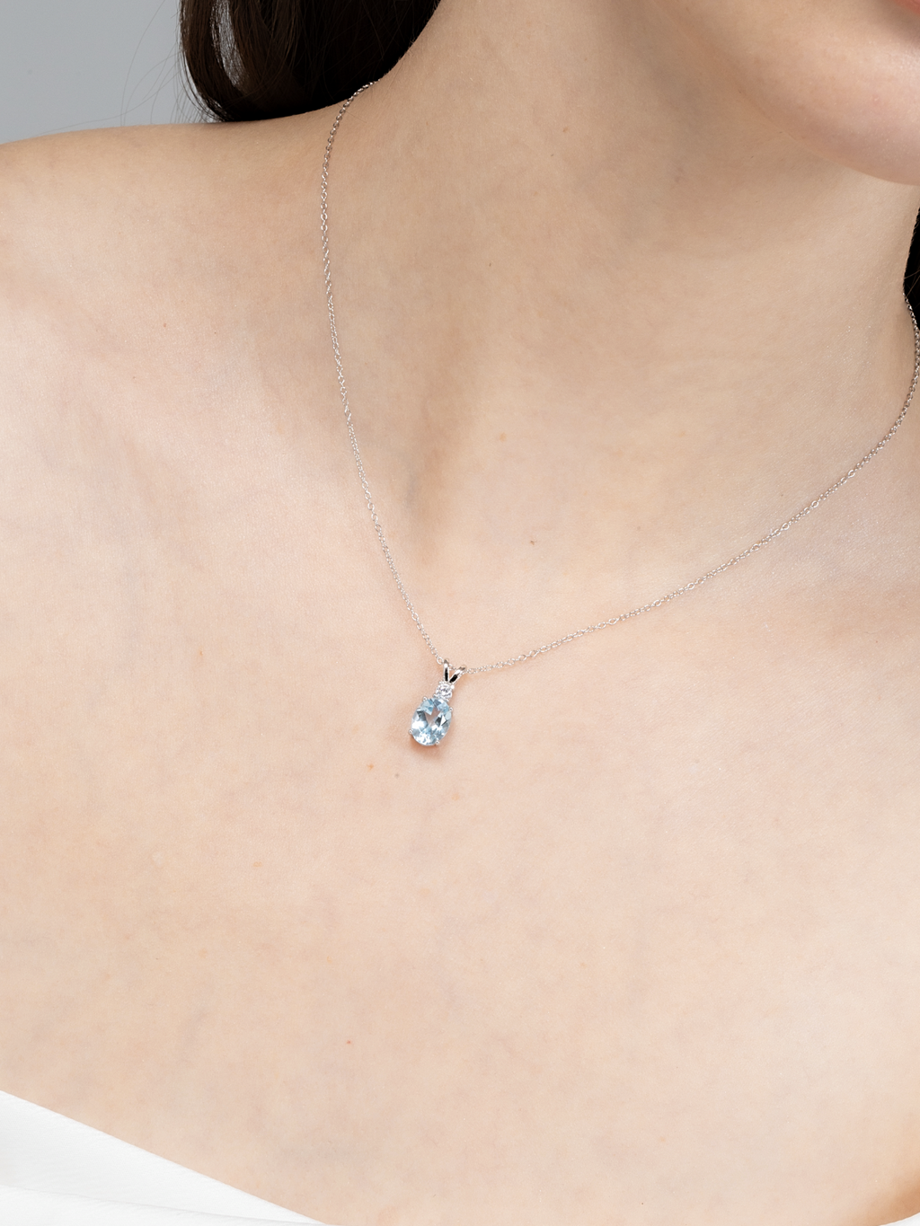 Blue topaz pendant necklace in sterling silver on neck