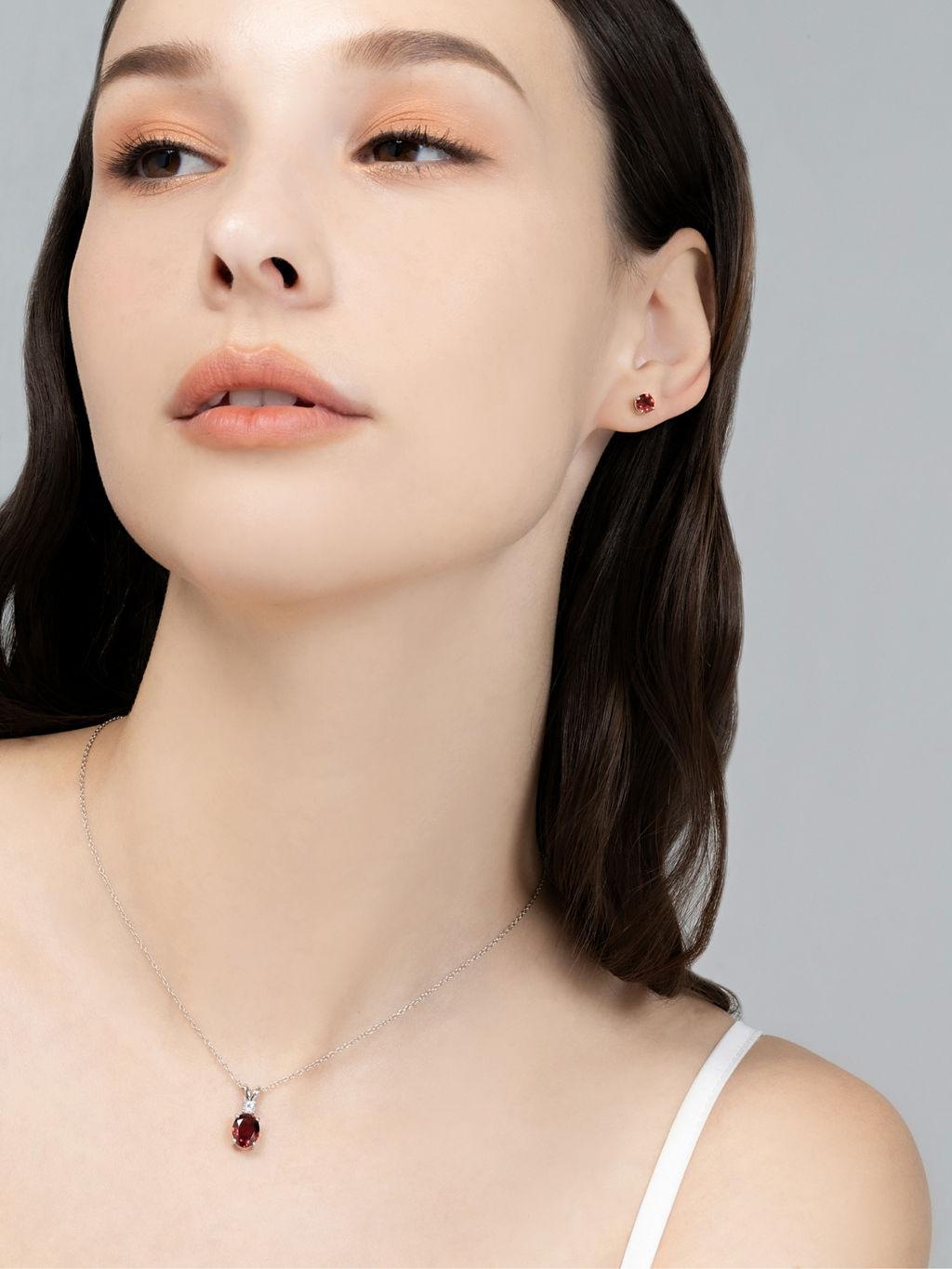 Model wearing red garnet necklace and ring set in sterling silver