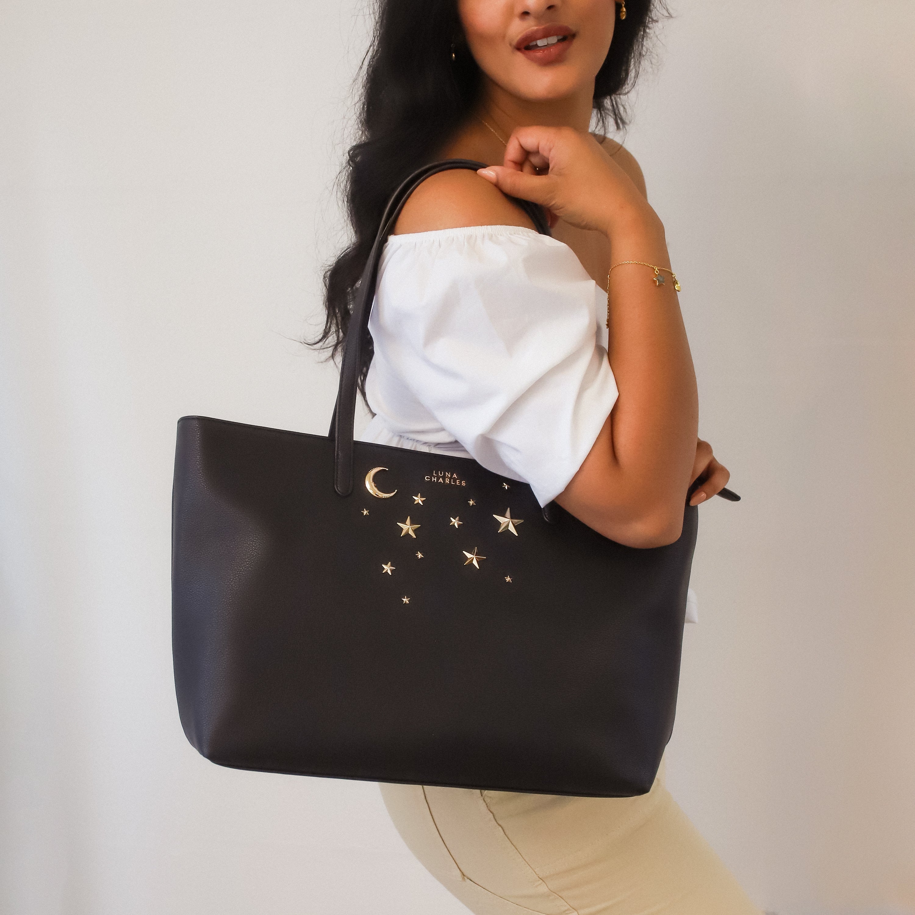 Luna Charles Anya black and gold star studded tote bag on model