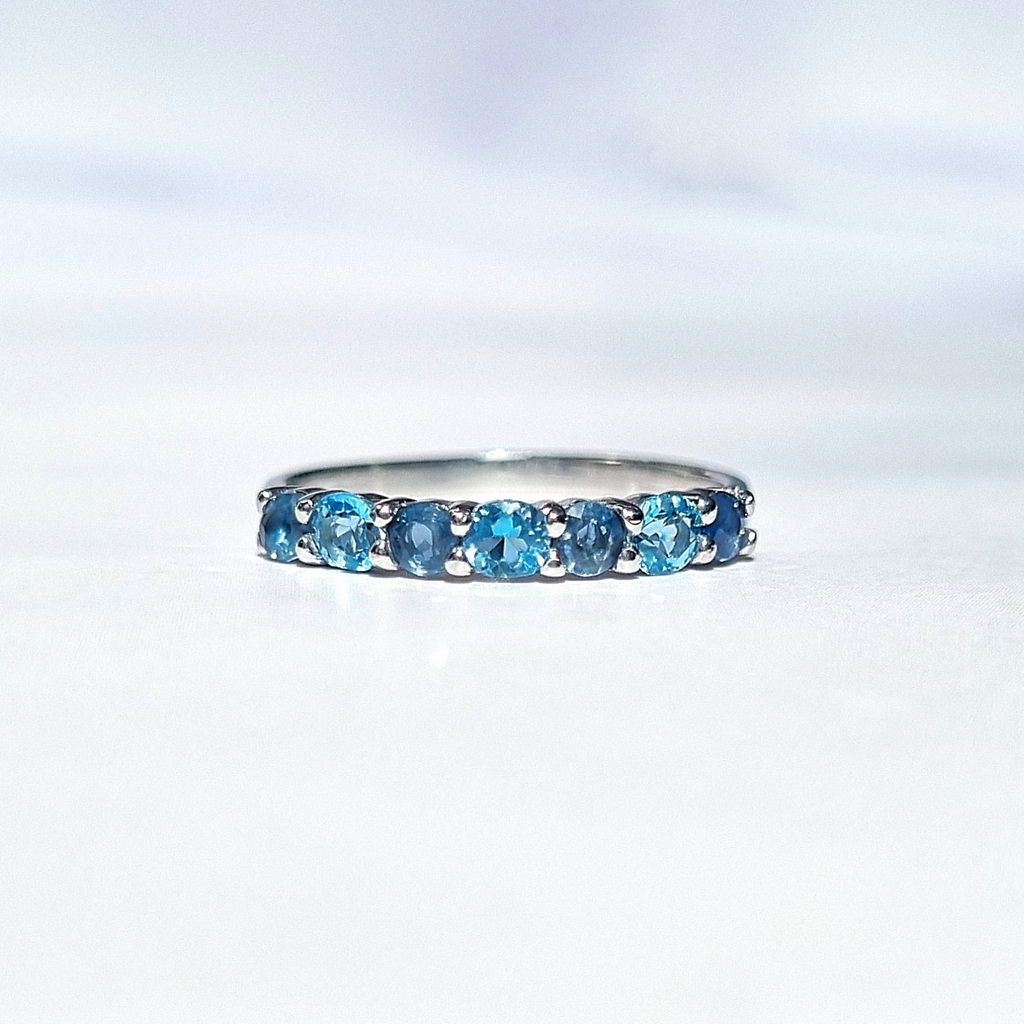 Blue sapphire and blue topaz half eternity ring in sterling silver detail image