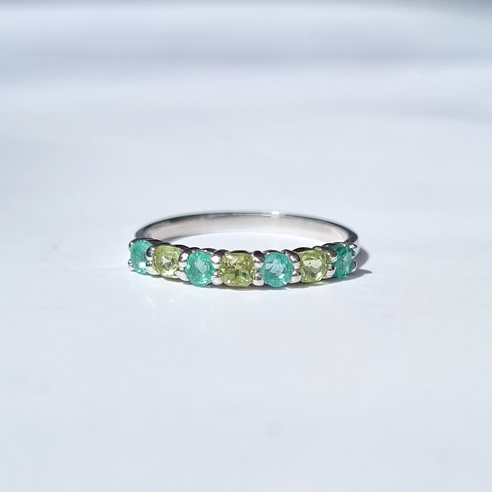 Emerald and peridot half eternity band in sterling silver detail image