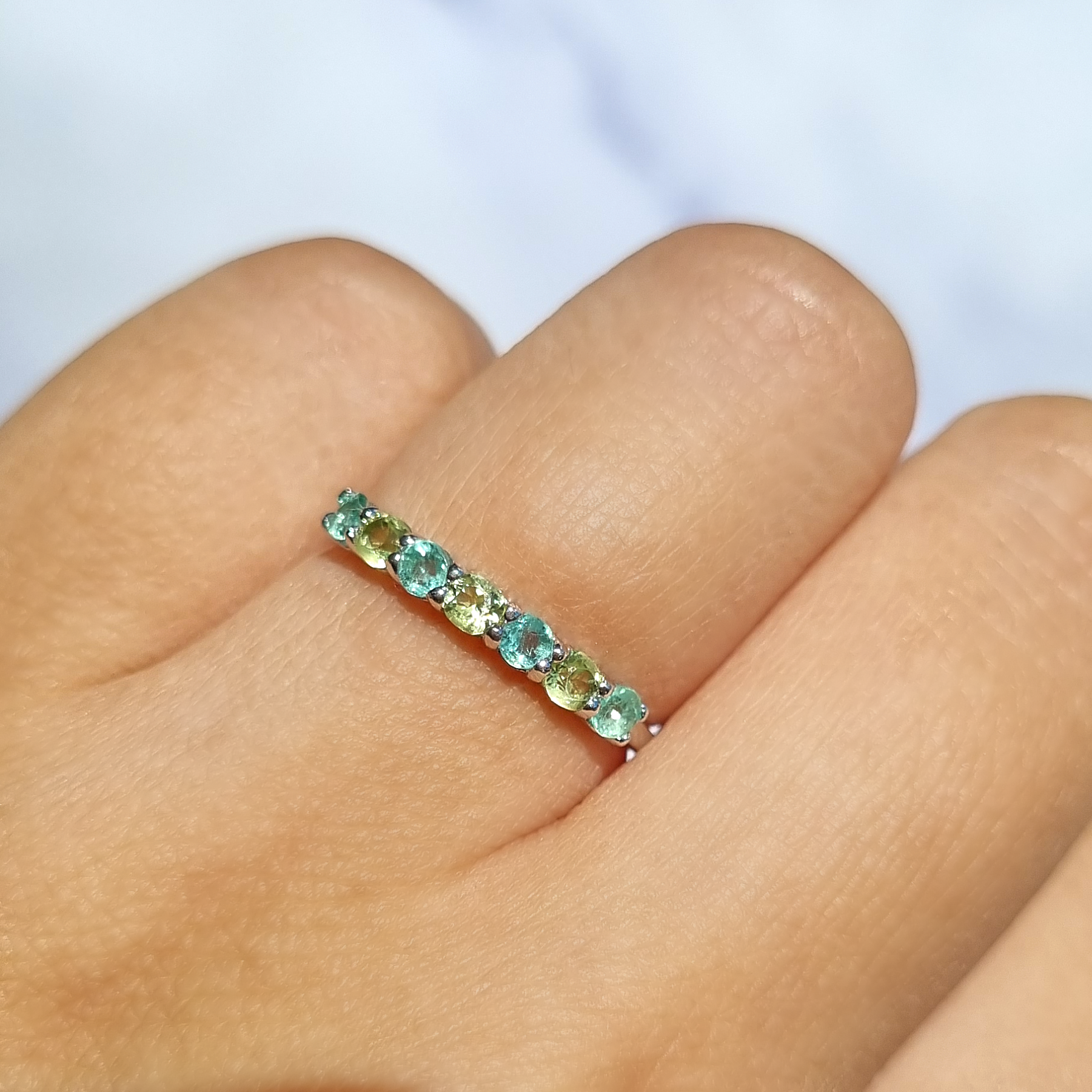 Emerald and peridot half eternity ring in sterling silver on hand