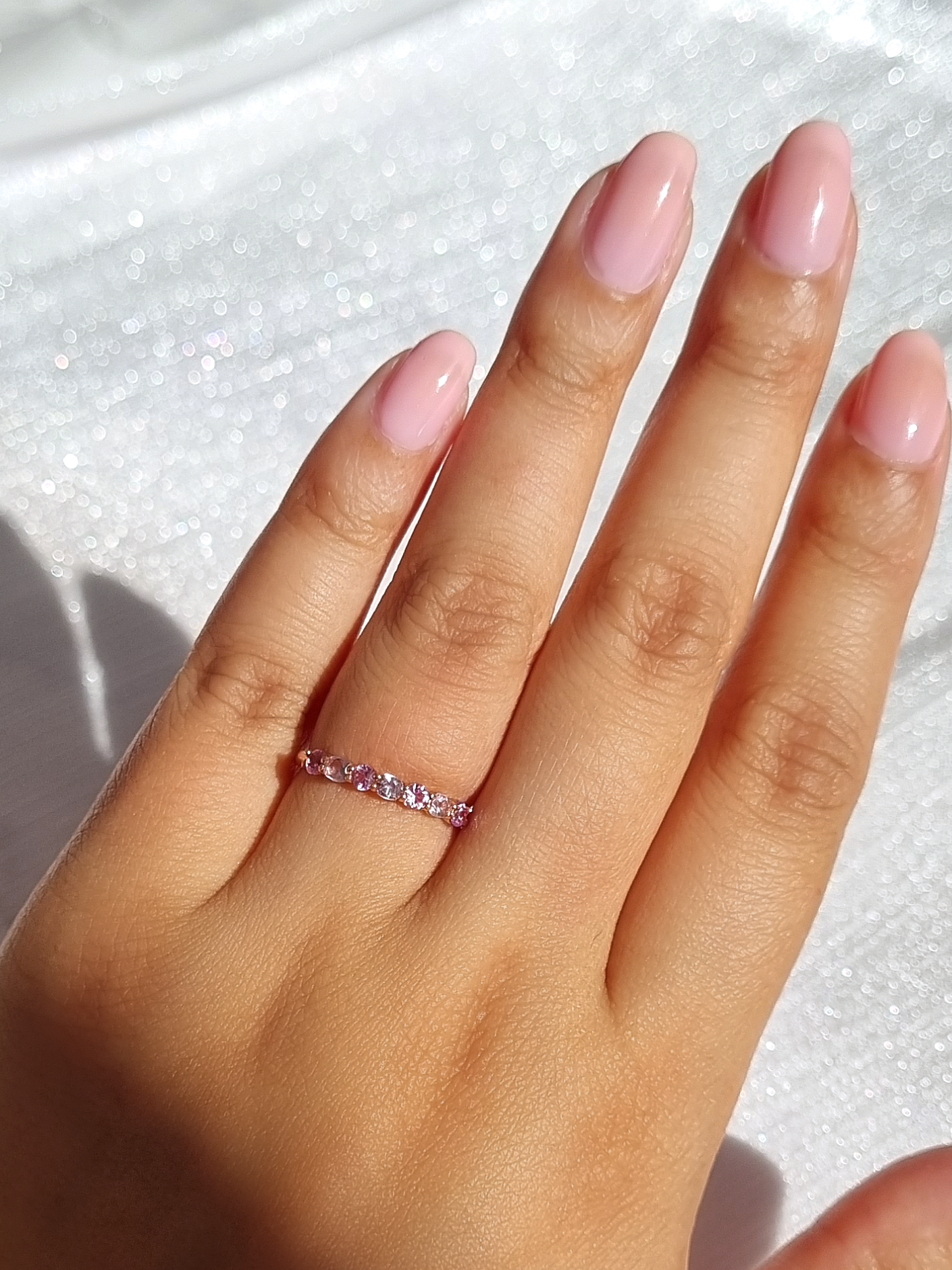 Pink sapphire and pink amethyst half eternity band in sterling silver on hand