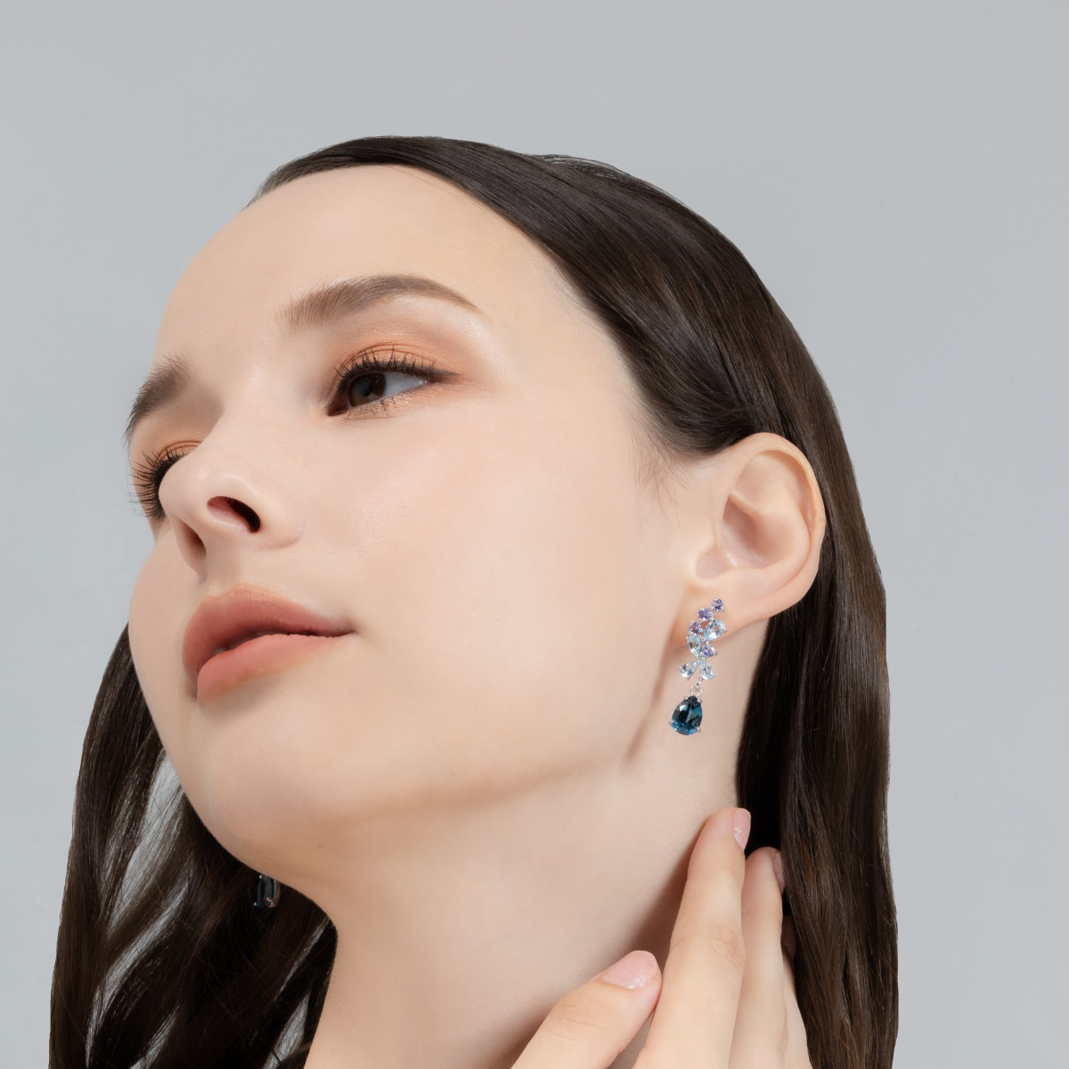Blue gemstone drop earrings in sterling silver on model