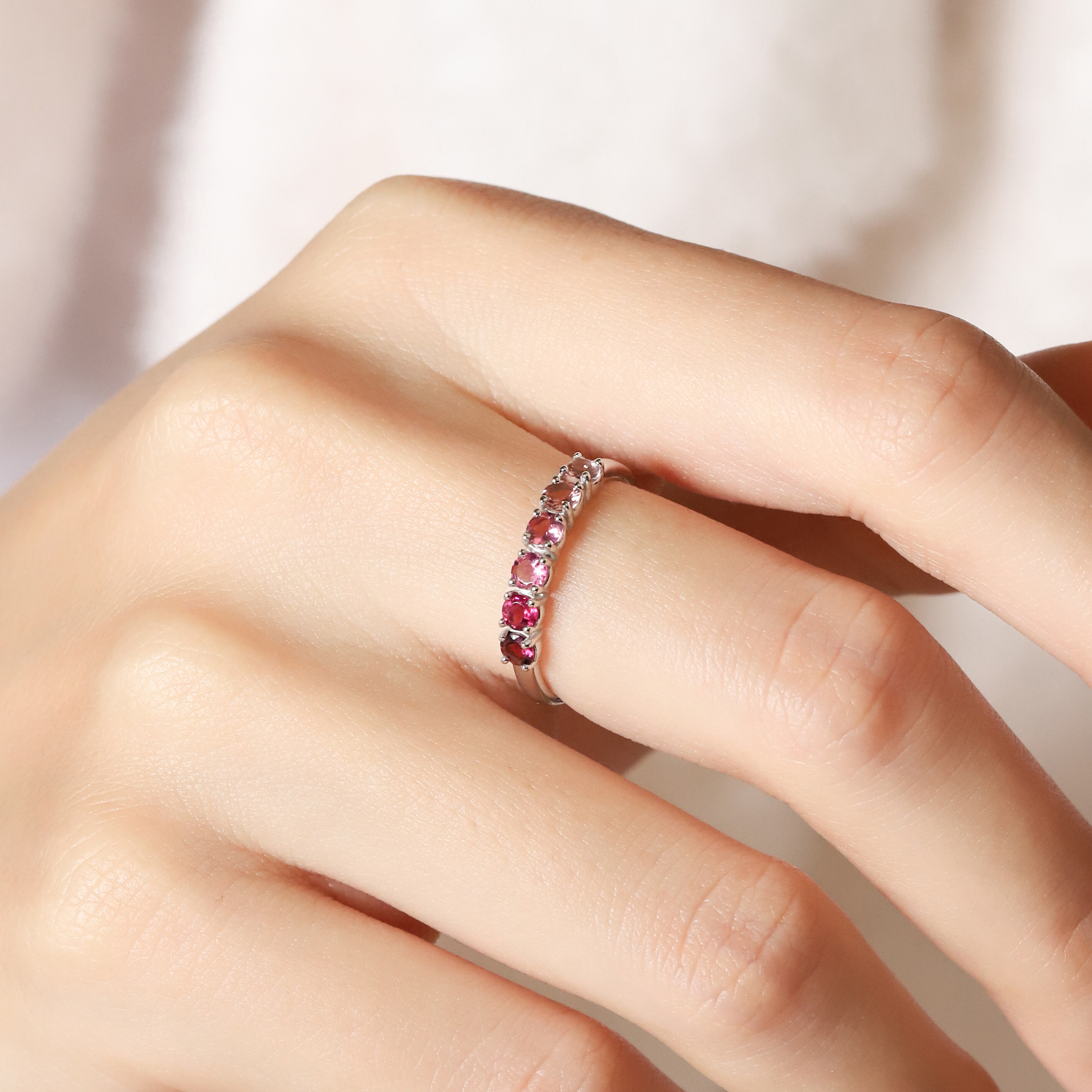 Ombre pink tourmaline eternity band in sterling silver on hand