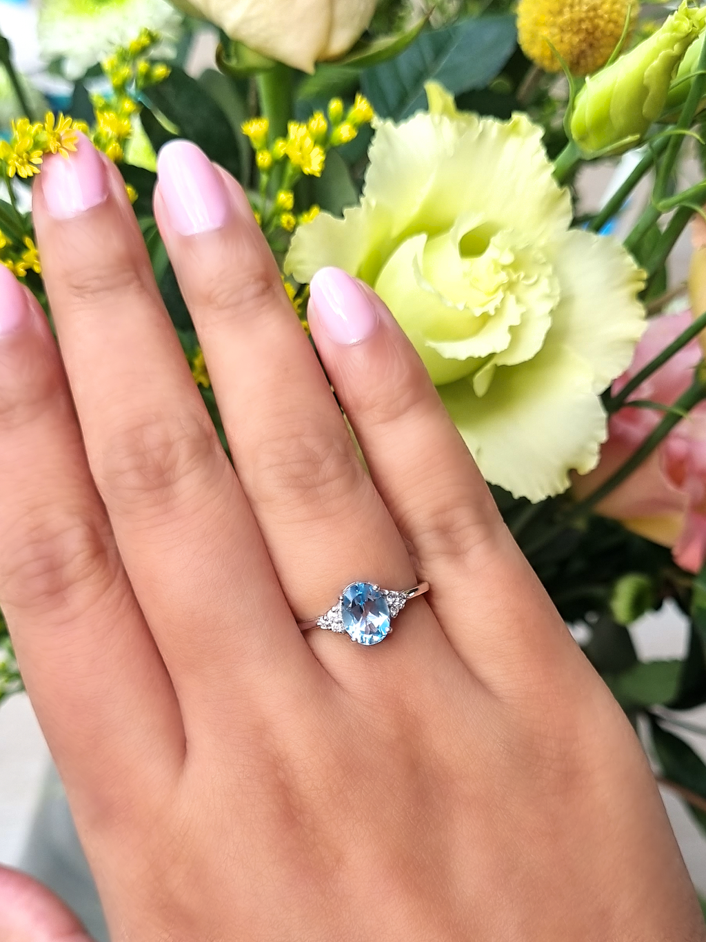 Sky blue topaz oval cut ring in sterling silver on hand detail image