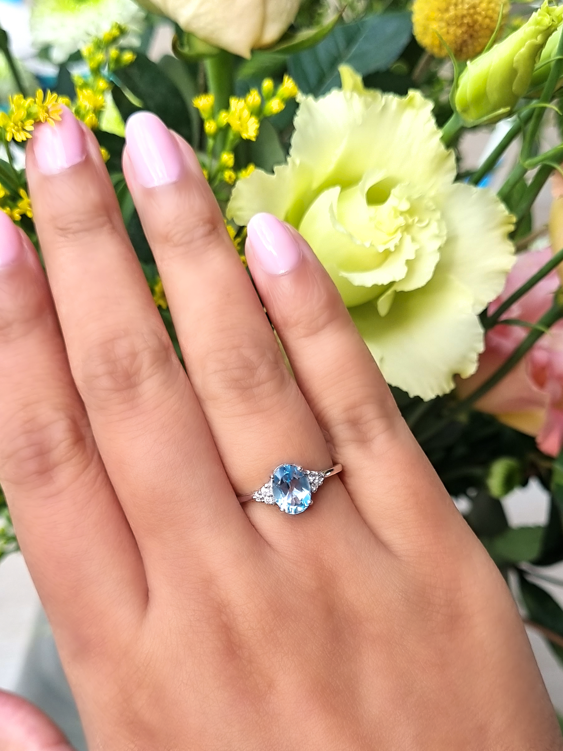 Sky blue topaz oval cut ring in sterling silver on hand detail image