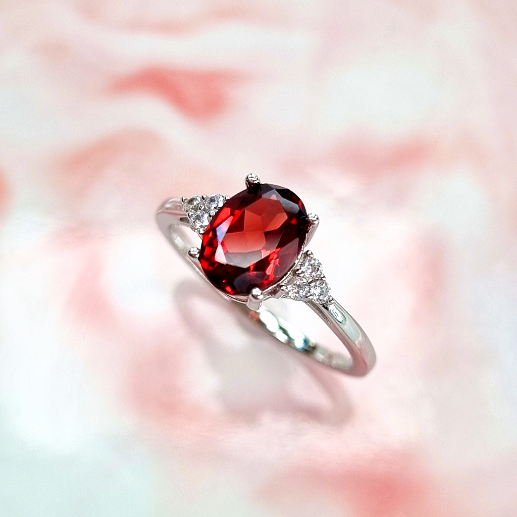 Garnet ring in sterling silver on pink background