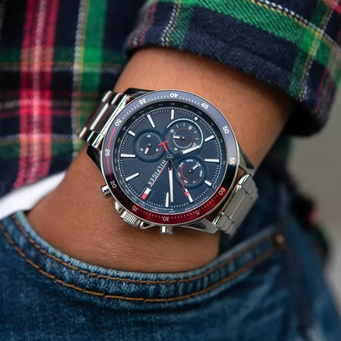 Tommy Hilfiger 1791718 watch on wrist near pockets with silver bracelet and blue dial