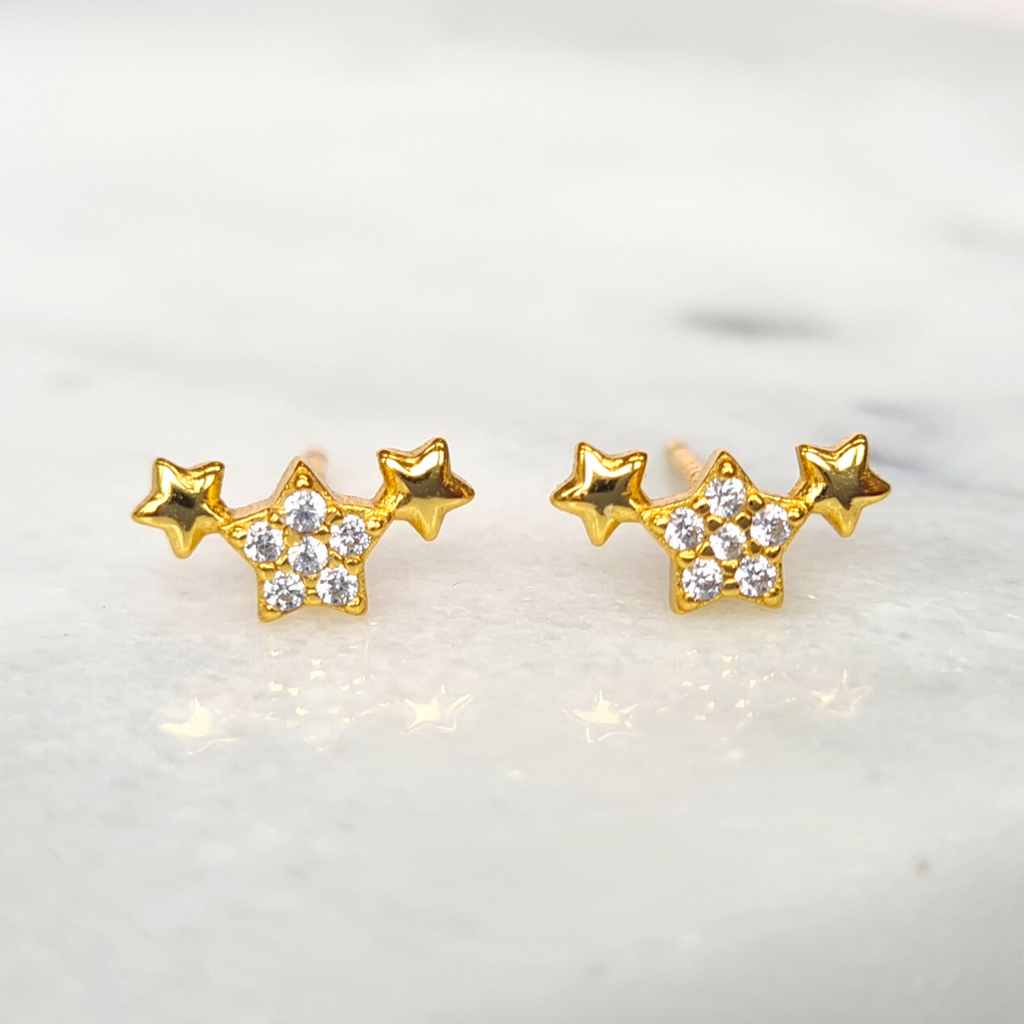 Gold trio of stars earrings styled image