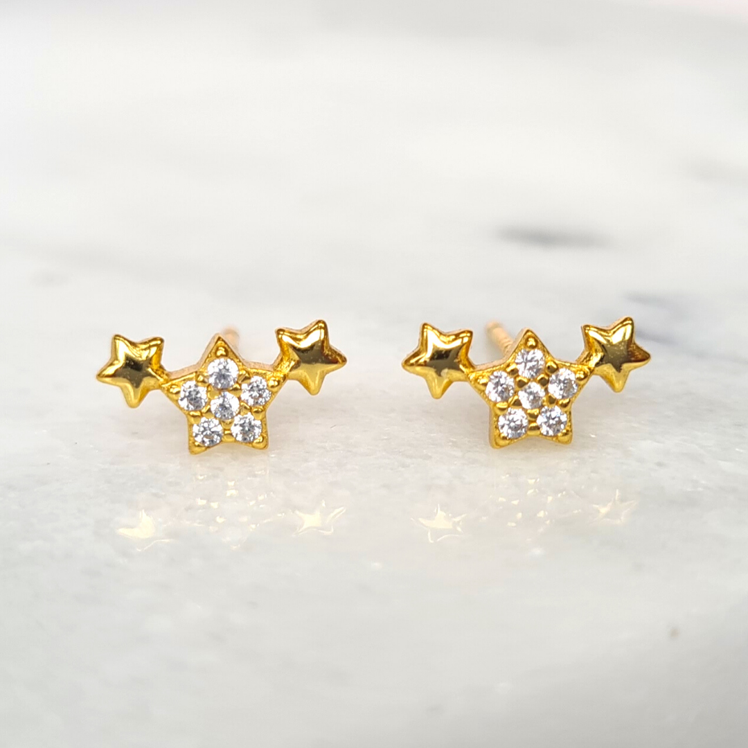 Gold trio of stars earrings styled image